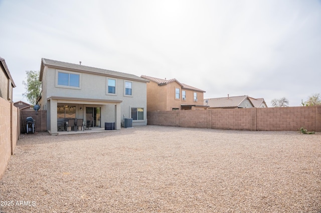 rear view of property with a patio area, a fenced backyard, central AC unit, and stucco siding