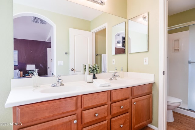 bathroom featuring visible vents, double vanity, a sink, and toilet