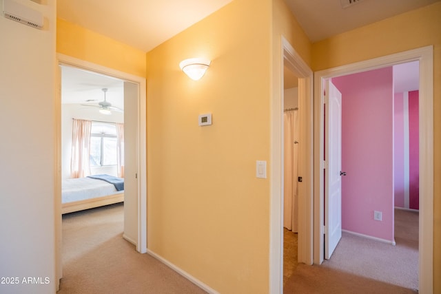 corridor with baseboards and carpet flooring