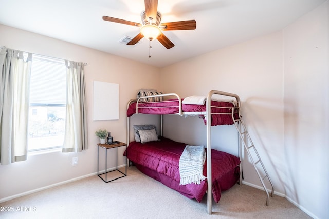 carpeted bedroom with visible vents, a ceiling fan, and baseboards