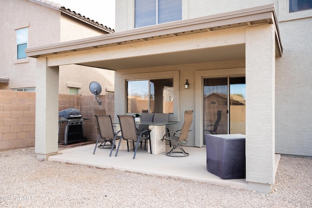 view of patio with outdoor dining area, grilling area, and fence