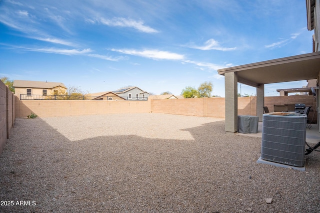 view of yard with central AC and a fenced backyard