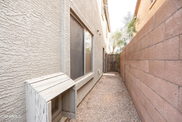 view of side of home with a gate and fence