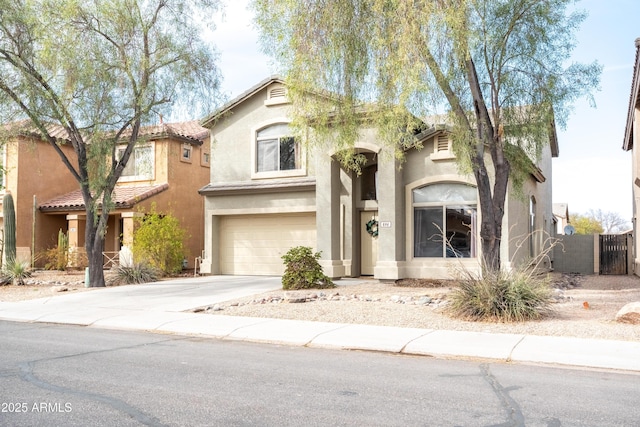 view of front of home with driveway, an attached garage, fence, and stucco siding