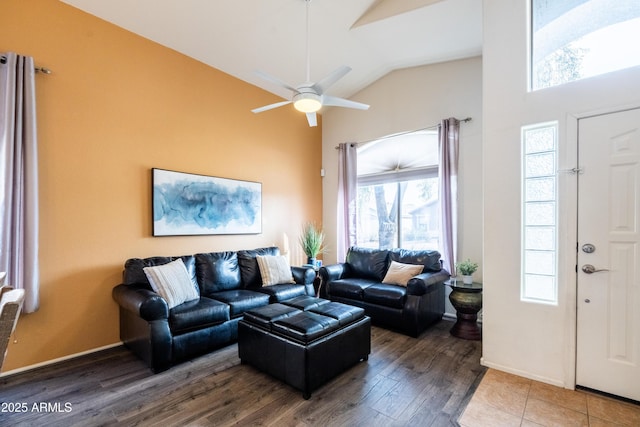 living room featuring a ceiling fan, baseboards, high vaulted ceiling, and wood finished floors