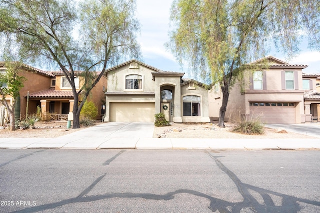 mediterranean / spanish-style home with an attached garage, driveway, a tiled roof, and stucco siding