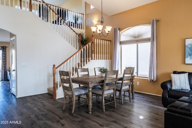 dining room with arched walkways, dark wood finished floors, a towering ceiling, and a notable chandelier