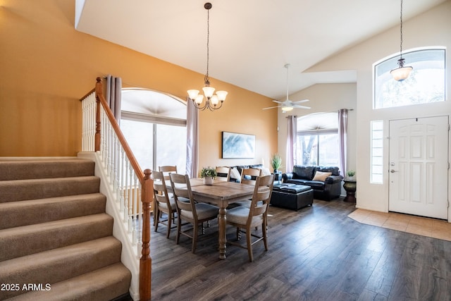 dining area with stairs, high vaulted ceiling, ceiling fan, and wood finished floors