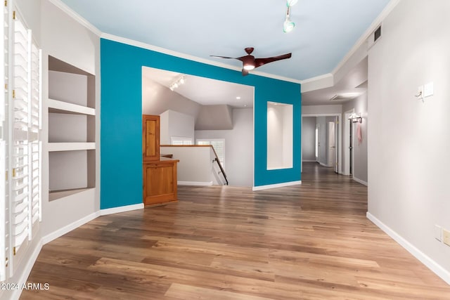 unfurnished living room featuring hardwood / wood-style flooring, built in features, crown molding, and ceiling fan