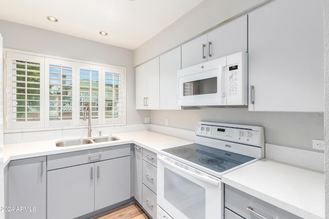 kitchen featuring a healthy amount of sunlight, sink, white appliances, and gray cabinetry