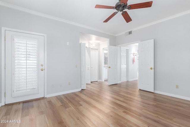 empty room featuring ceiling fan, light hardwood / wood-style floors, and crown molding