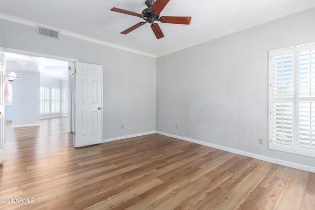 empty room with wood-type flooring, ceiling fan with notable chandelier, and ornamental molding