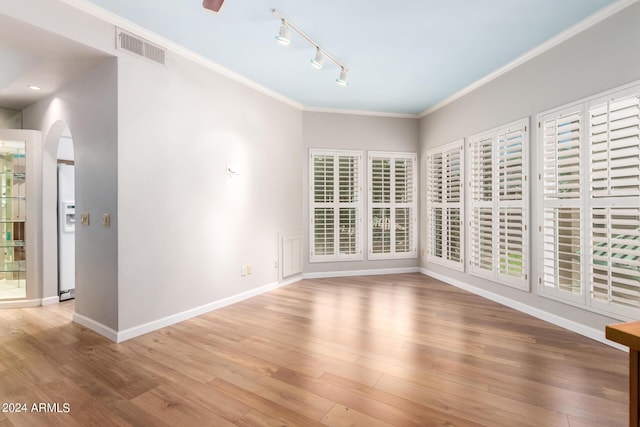 spare room with ornamental molding and hardwood / wood-style floors