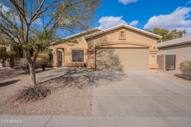 mediterranean / spanish-style home featuring a garage, a tile roof, driveway, and stucco siding