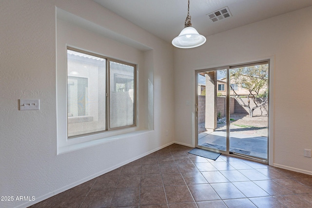 unfurnished room with dark tile patterned floors, baseboards, and visible vents