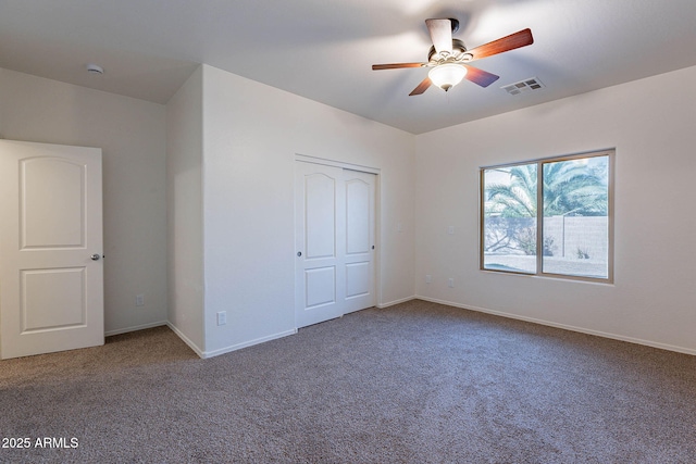 unfurnished bedroom with carpet floors, baseboards, visible vents, and a closet