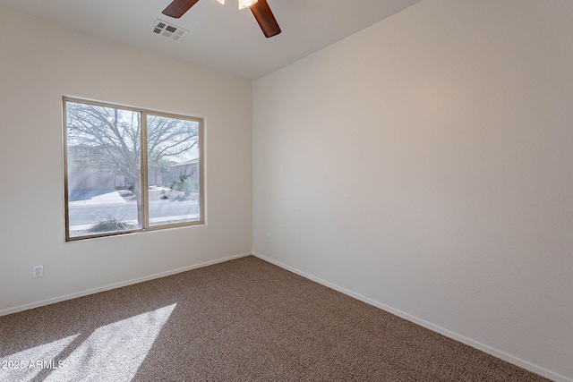 empty room with carpet floors, baseboards, visible vents, and ceiling fan