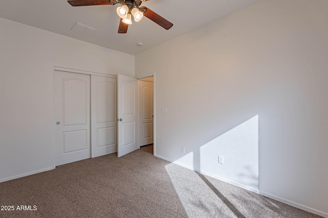 unfurnished bedroom with ceiling fan, carpet floors, a closet, and baseboards