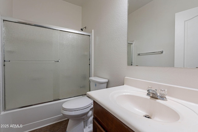 full bath featuring tile patterned flooring, vanity, toilet, and bath / shower combo with glass door