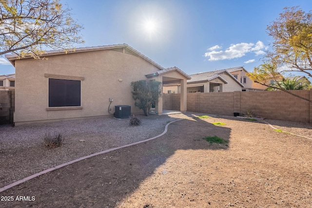 rear view of property featuring stucco siding, a fenced backyard, cooling unit, and a patio