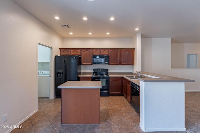 kitchen with visible vents, a center island, black appliances, a sink, and recessed lighting