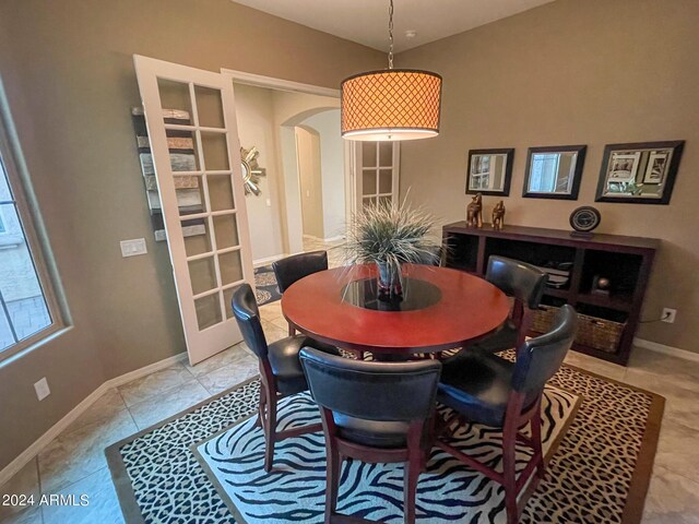 27002 W Oraibi Dr, Buckeye, AZ 85396 - dining room with light tile patterned floors, arched walkways, and baseboards