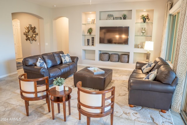 27002 W Oraibi Dr, Buckeye, AZ 85396 - living room featuring built in shelves, arched walkways, and baseboards