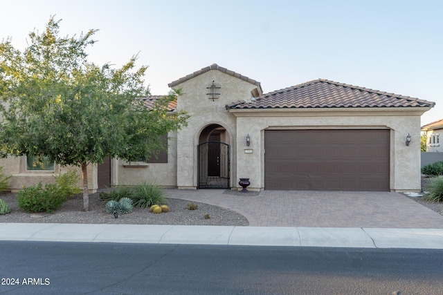 27002 W Oraibi Dr, Buckeye, AZ 85396 - mediterranean / spanish-style home featuring a garage, stucco siding, driveway, and a tiled roof