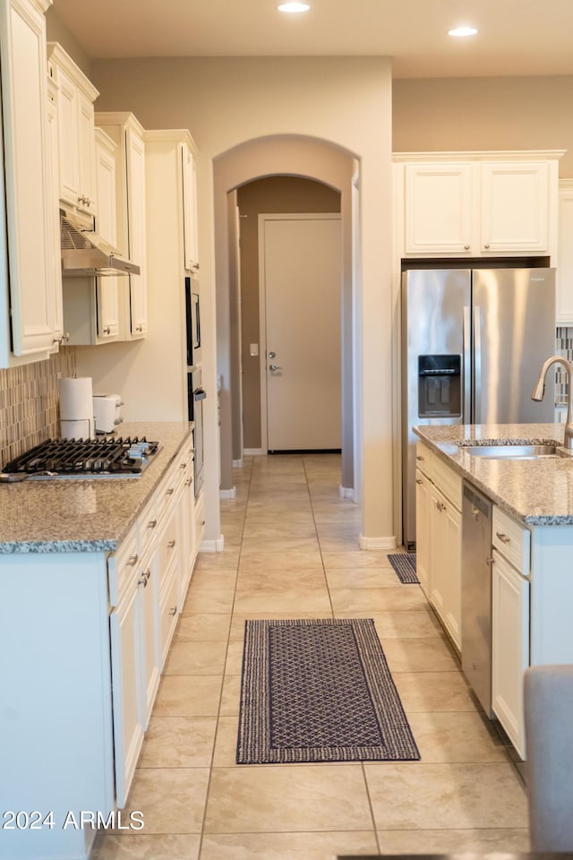 27002 W Oraibi Dr, Buckeye, AZ 85396 - kitchen featuring recessed lighting, a sink, under cabinet range hood, arched walkways, and appliances with stainless steel finishes