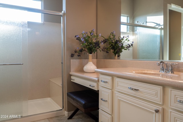 bathroom featuring tile patterned flooring, vanity, and walk in shower