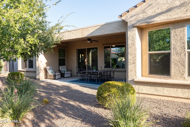 rear view of property with ceiling fan and a patio