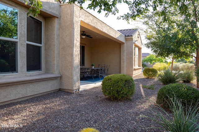 view of property exterior with ceiling fan and a patio area