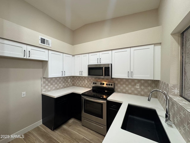 kitchen featuring backsplash, appliances with stainless steel finishes, sink, and white cabinets