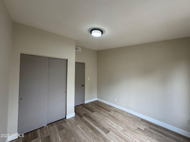 unfurnished bedroom featuring light hardwood / wood-style floors and a closet