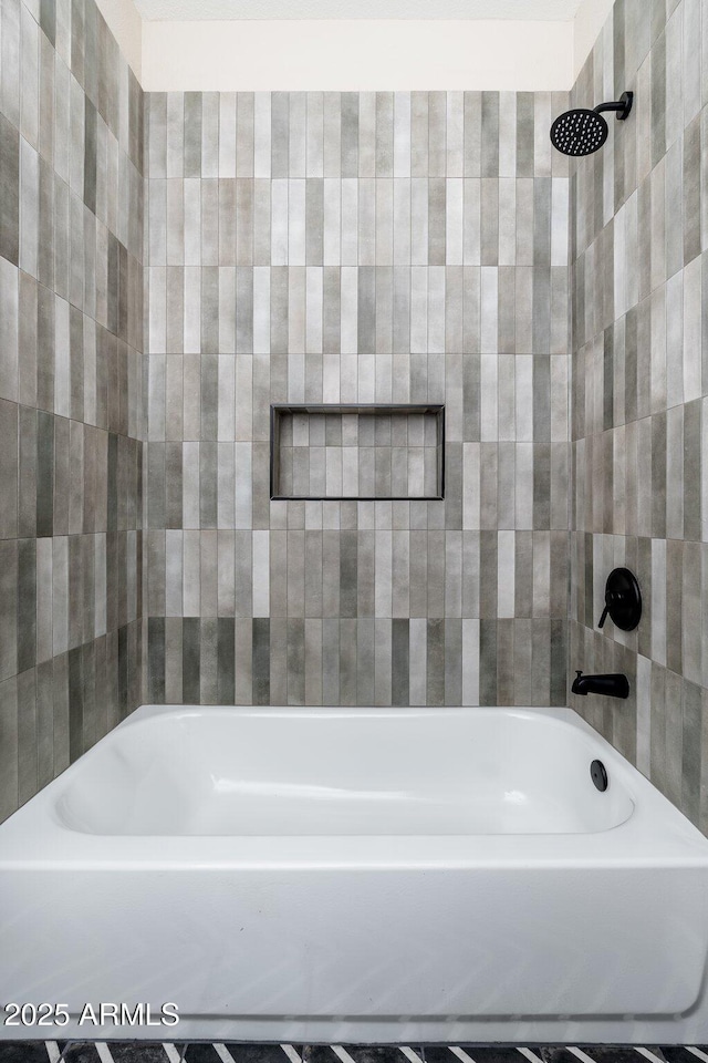 bathroom featuring tiled shower / bath