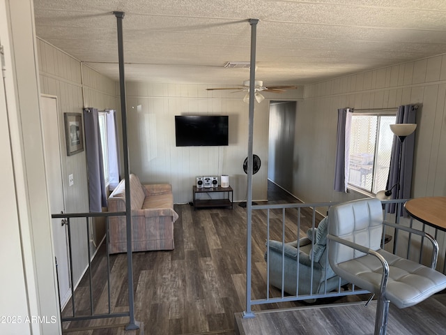 1776 S Lawson Dr, Apache Junction, AZ 85120 - living room featuring ceiling fan, wood finished floors, wood walls, and a textured ceiling