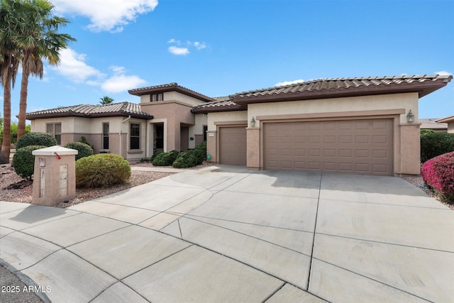 mediterranean / spanish-style house with an attached garage, driveway, a tiled roof, and stucco siding