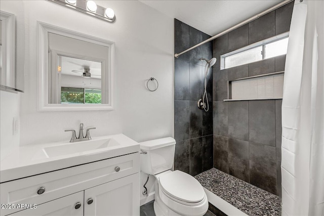 bathroom with a wealth of natural light, a tile shower, toilet, and vanity