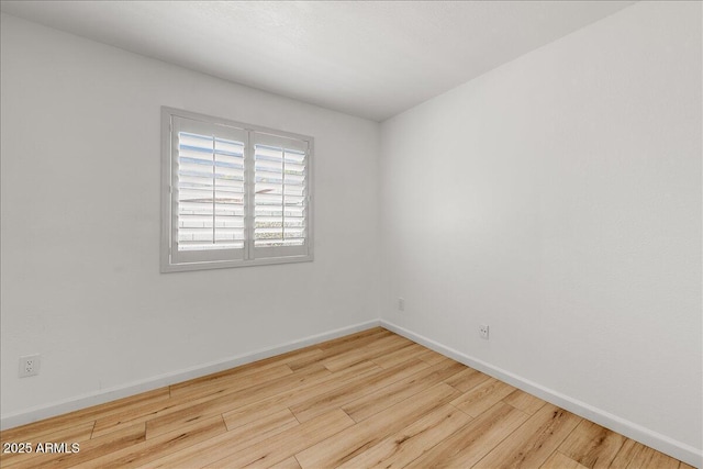 spare room featuring wood finished floors and baseboards