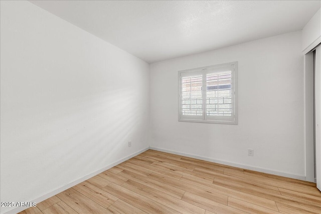 empty room with baseboards and wood finished floors