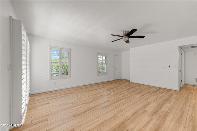 empty room featuring visible vents, baseboards, light wood-style flooring, and a ceiling fan