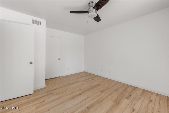 unfurnished room featuring visible vents, baseboards, ceiling fan, and wood finished floors