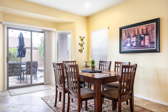 dining space featuring light tile patterned floors and baseboards