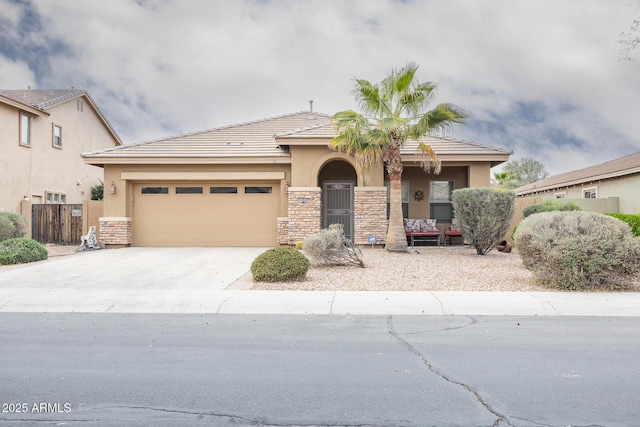 view of front of home with driveway, stone siding, an attached garage, and stucco siding