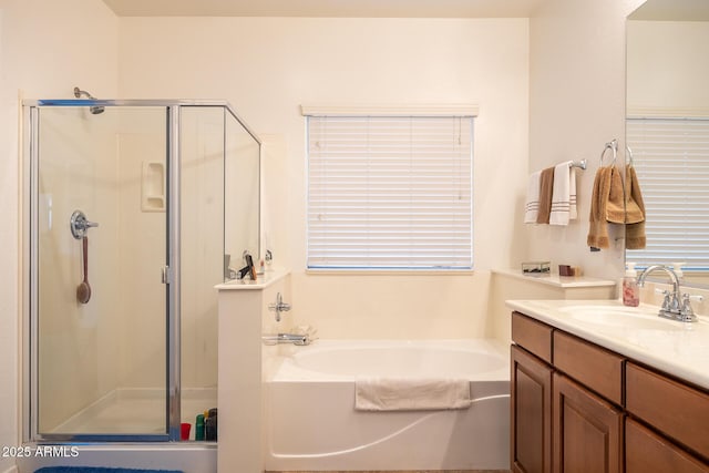 bathroom featuring a stall shower, a garden tub, and vanity