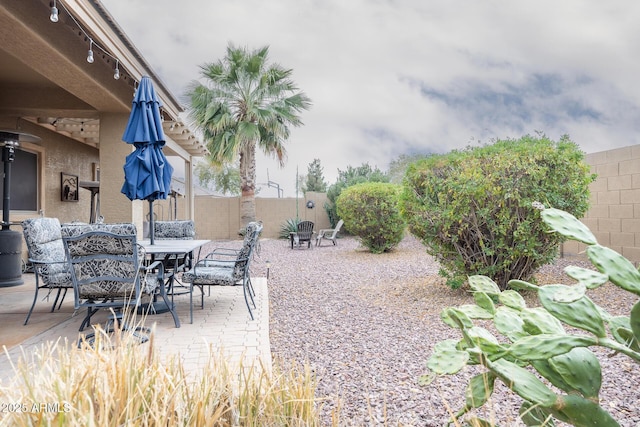 view of yard featuring outdoor dining area, a fenced backyard, and a patio