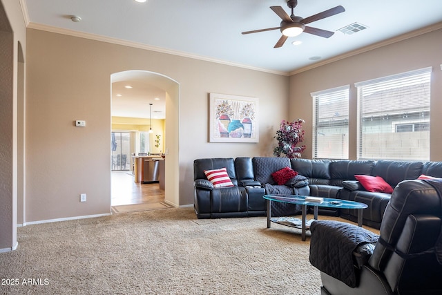 living room featuring arched walkways, carpet flooring, visible vents, and a healthy amount of sunlight