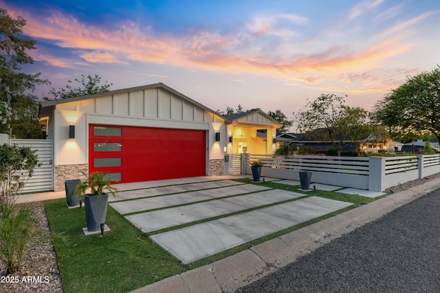 3429 E Coolidge St, Phoenix, AZ 85018 - contemporary home featuring stone siding, board and batten siding, an attached garage, and a fenced front yard