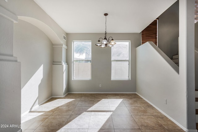 unfurnished dining area featuring a chandelier and light tile patterned flooring