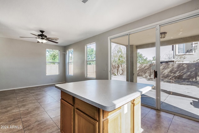 kitchen featuring ceiling fan, a center island, and tile patterned floors